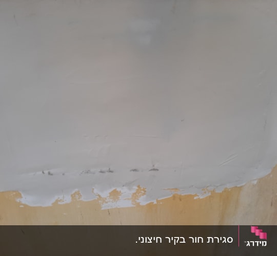 תמונת תקריב של מריחת שפכטל וחומר החלקה לתיקון קיר